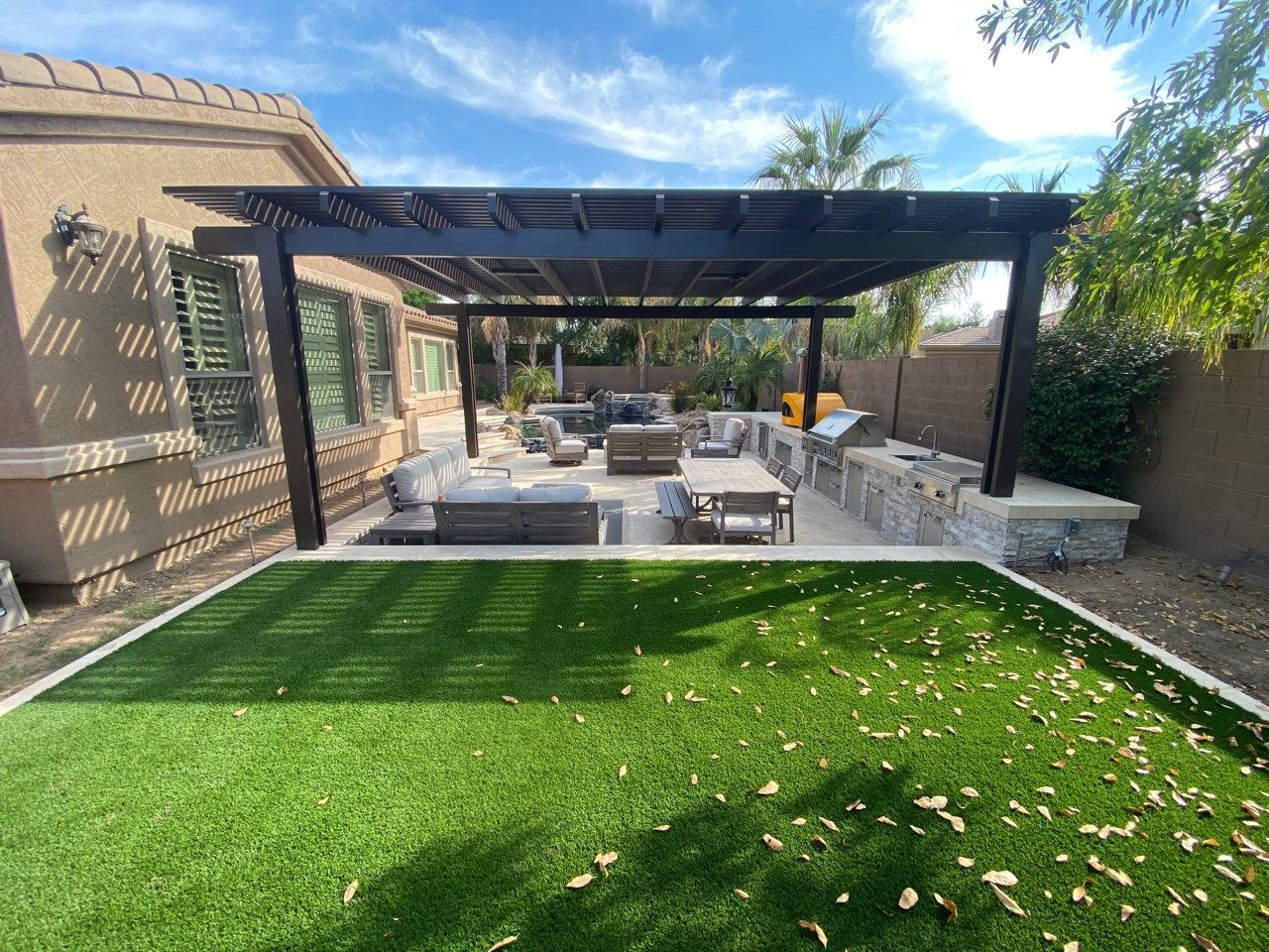 There is a pergola in the backyard of a house.