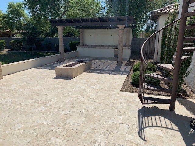 A patio with a spiral staircase and a fire pit