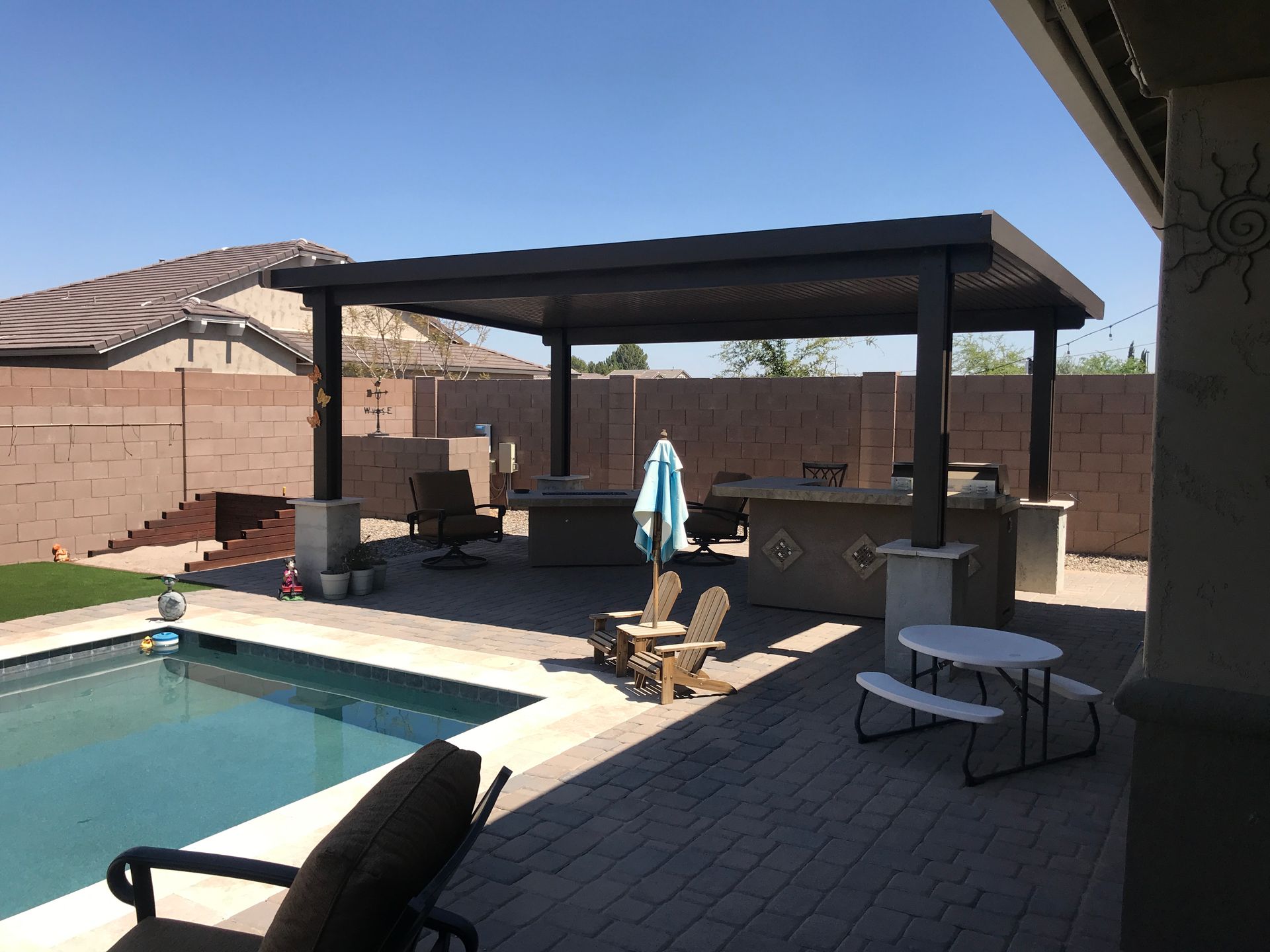 A patio area with a swimming pool and a picnic table