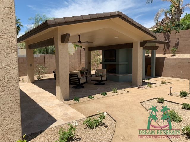 A house with a covered patio and a palm tree in the background