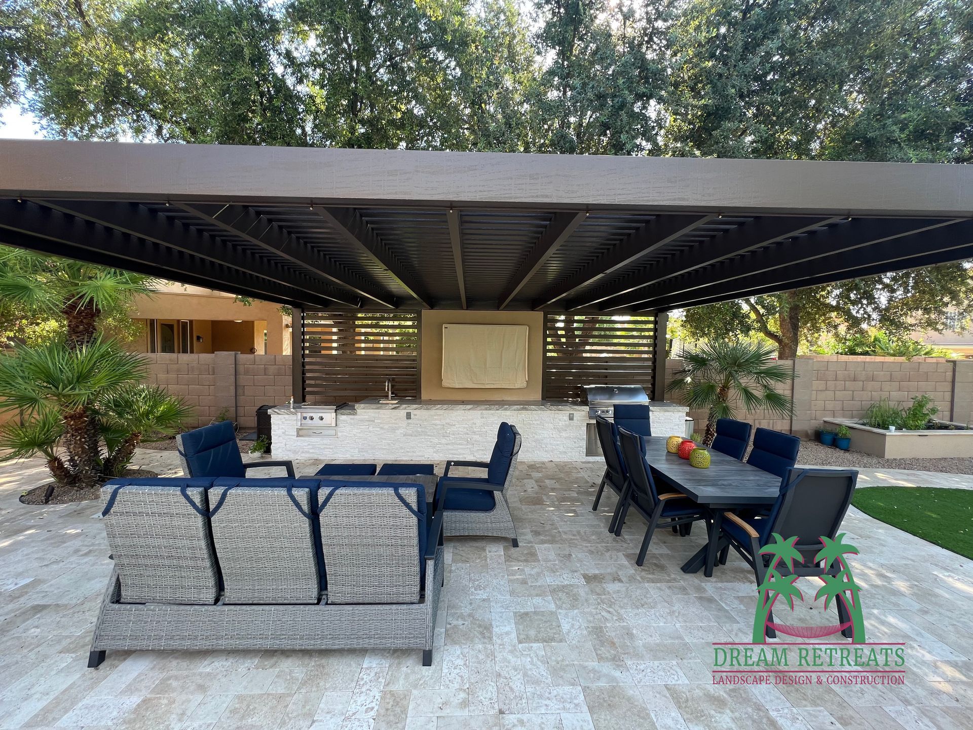 A patio with a couch , table and chairs under a canopy.