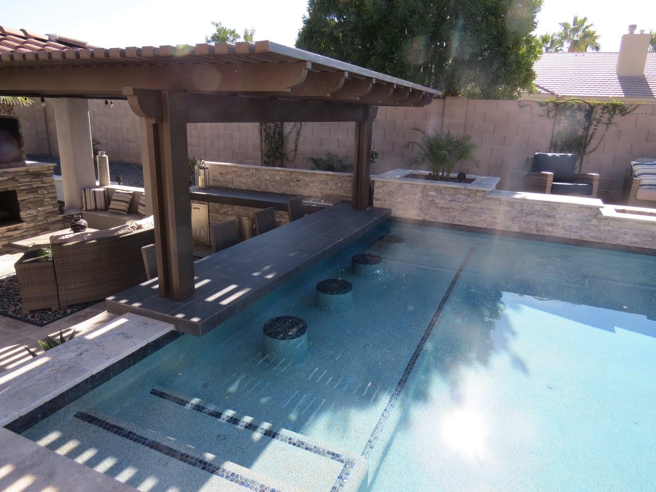 A large swimming pool with a bar underneath it