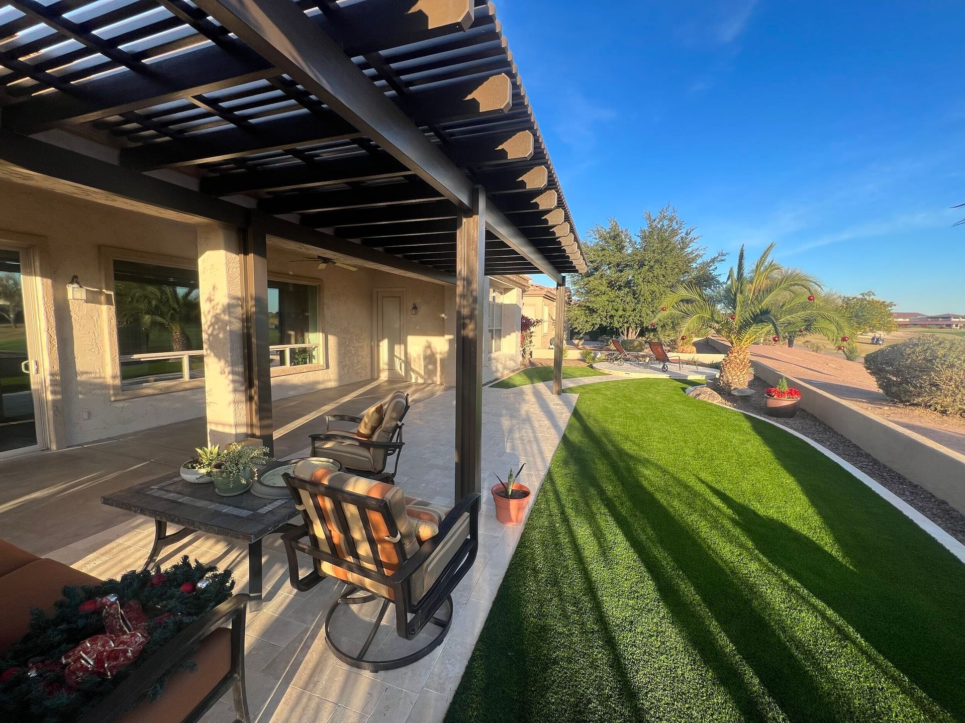 A patio with a table and chairs under a pergola.