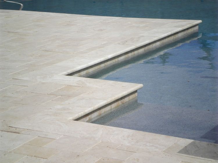 A swimming pool with a tiled deck and steps