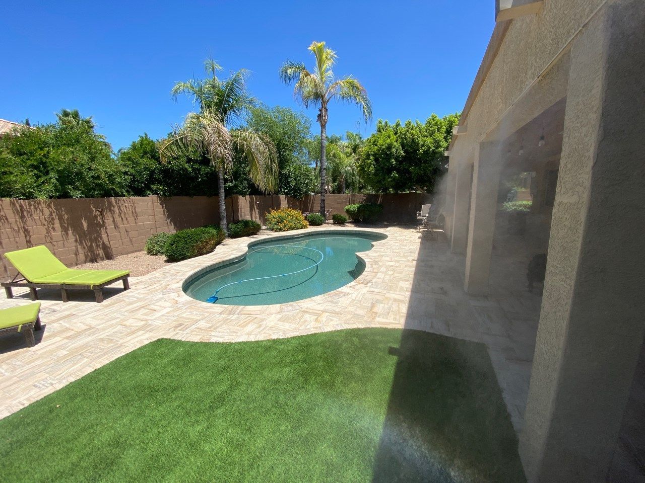 A swimming pool in the backyard of a house