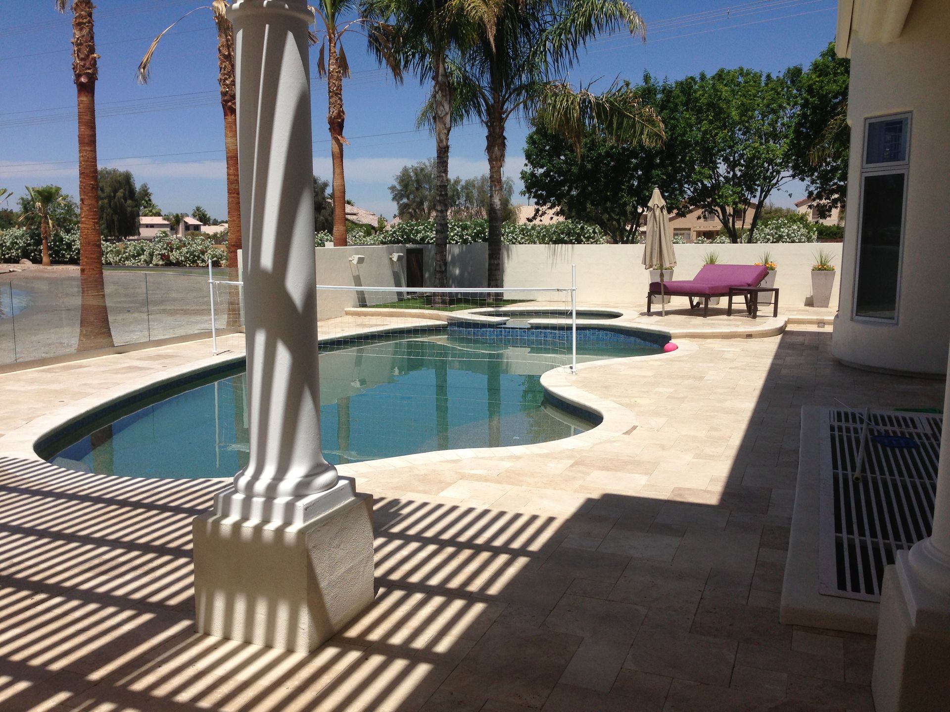 A large swimming pool is surrounded by palm trees