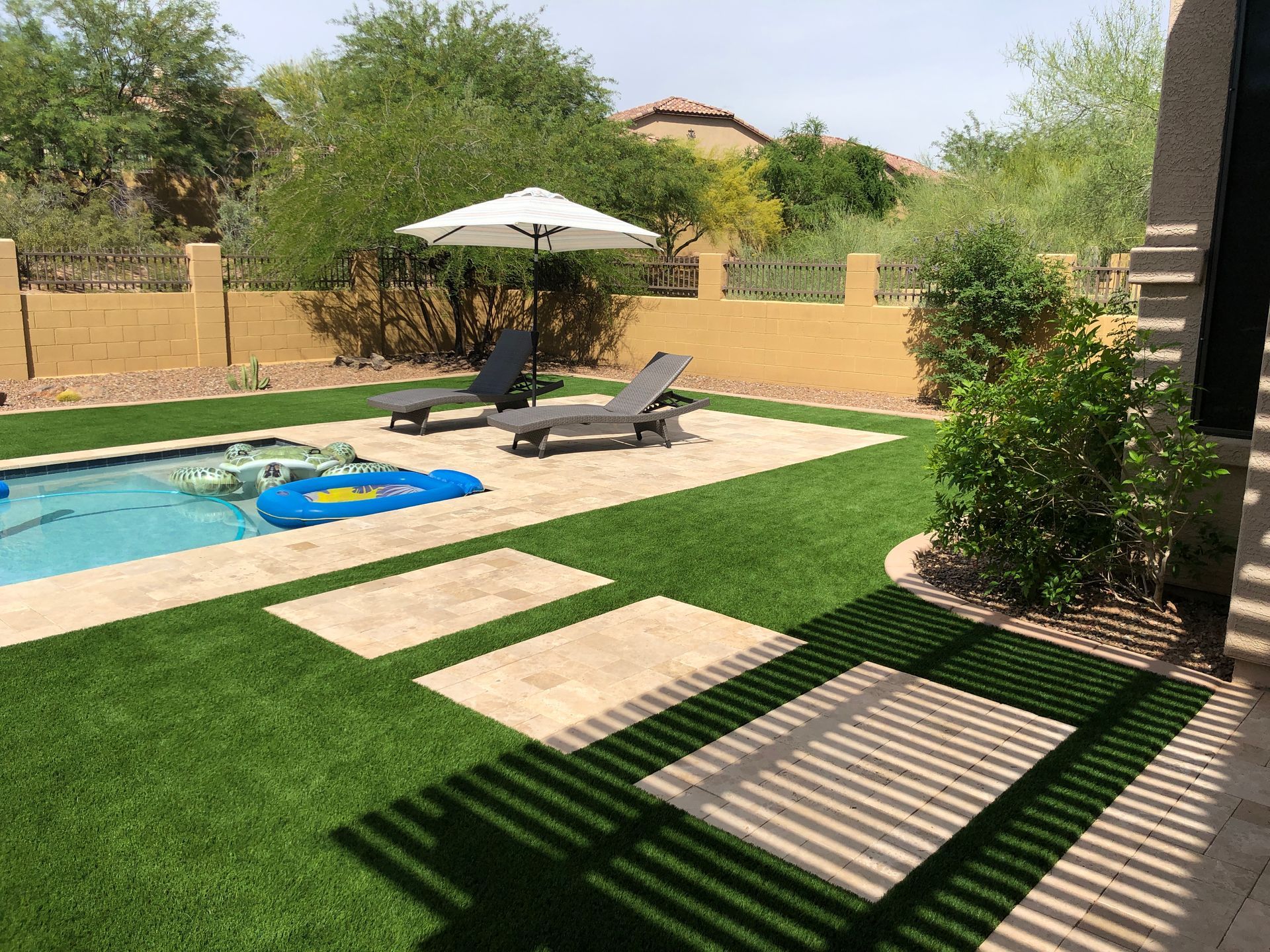 A backyard with a swimming pool and lawn chairs