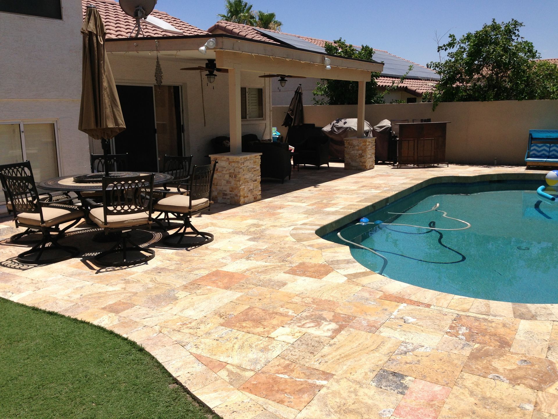 A large swimming pool with tables and chairs around it