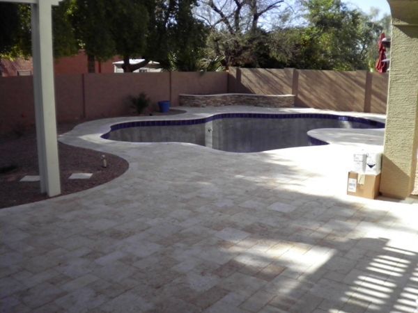 A patio with a swimming pool in the background