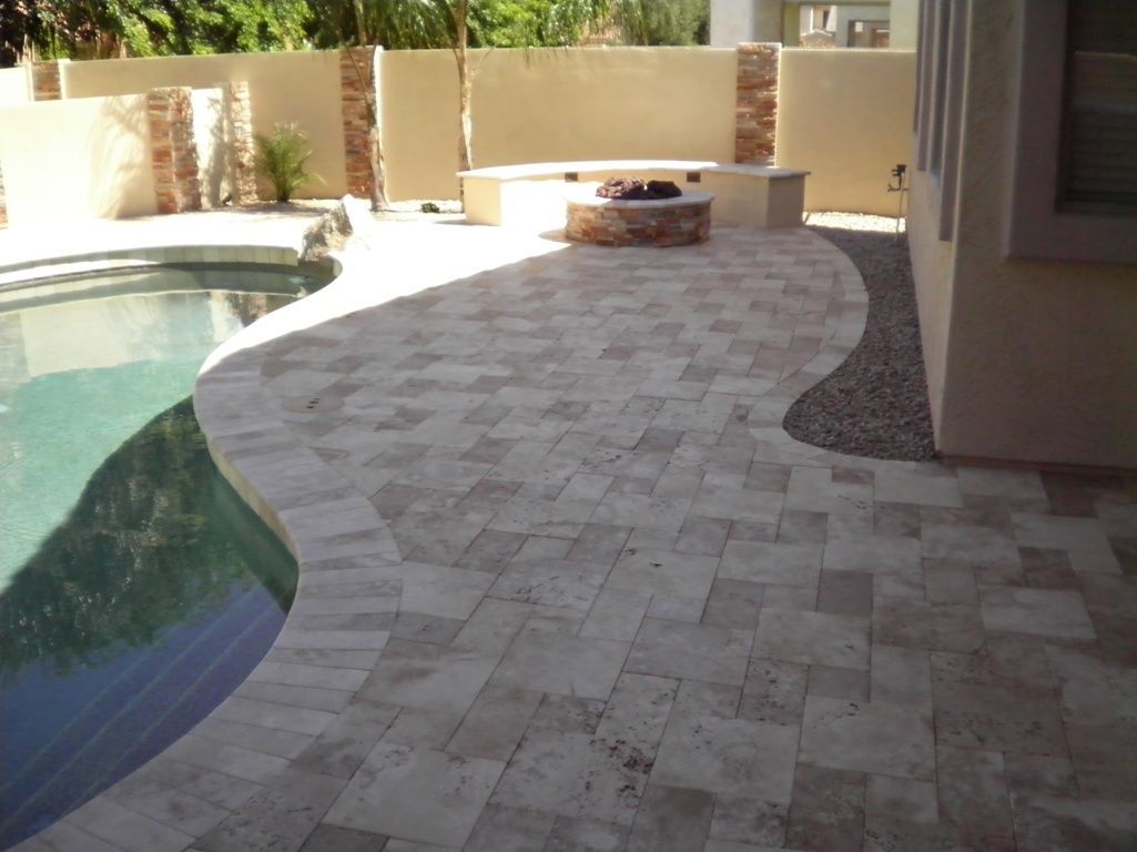 A patio with a swimming pool in the background
