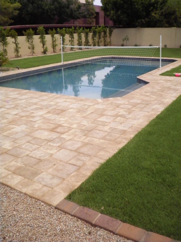 A large swimming pool with a volleyball net in the background