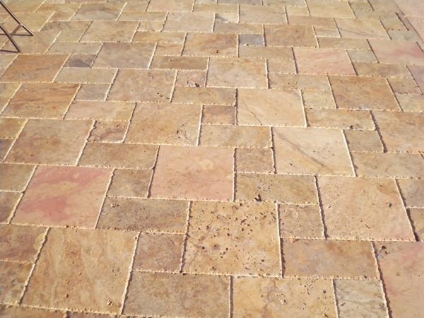 A close up of a brick floor with a chair in the background