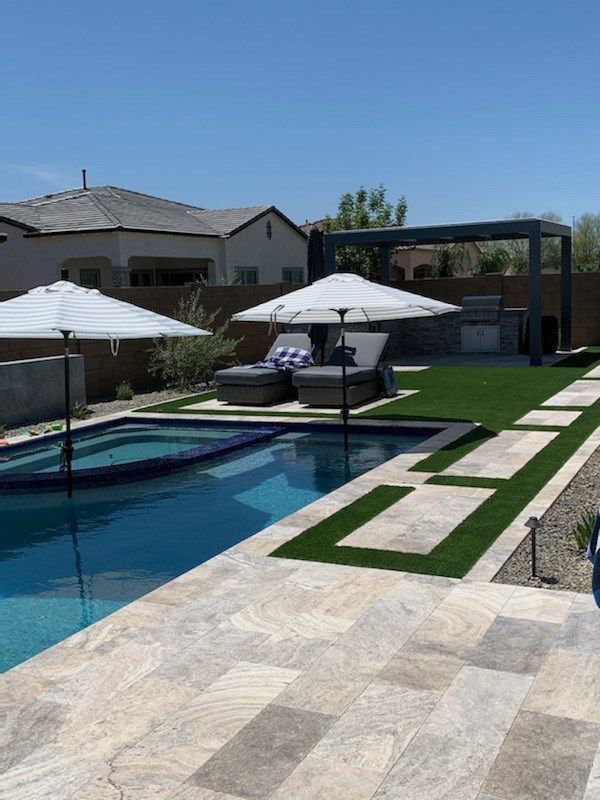 A large swimming pool with umbrellas and chairs around it