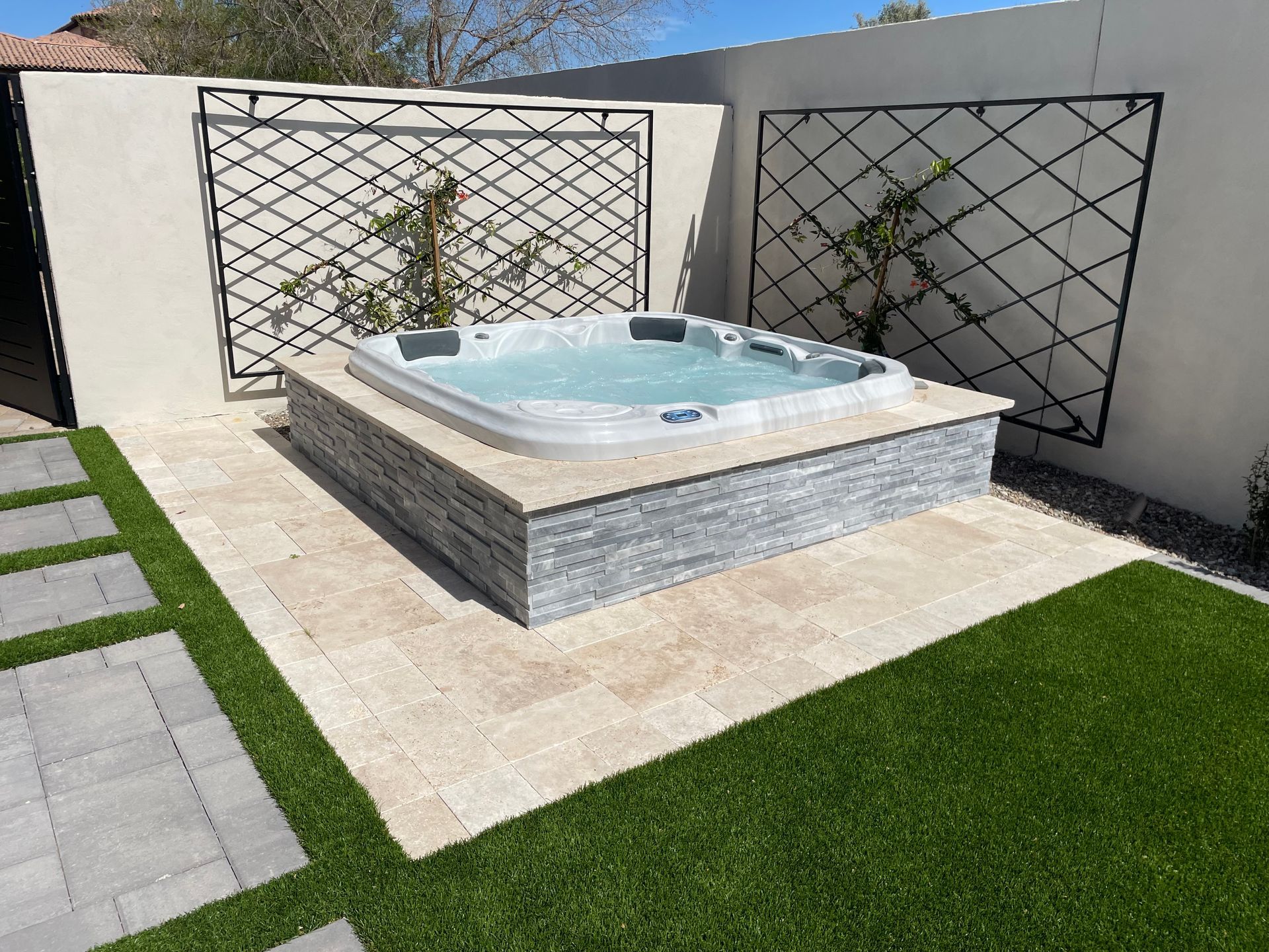 A hot tub is sitting in the middle of a lush green yard.