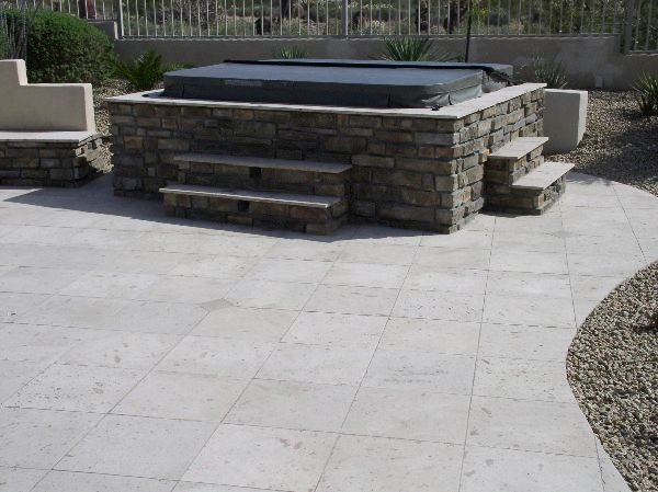 A stone hot tub with stairs leading up to it