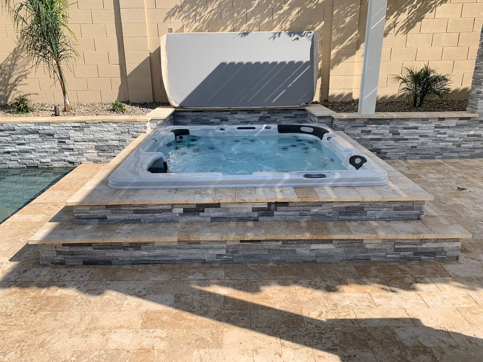 A hot tub is sitting next to a swimming pool.