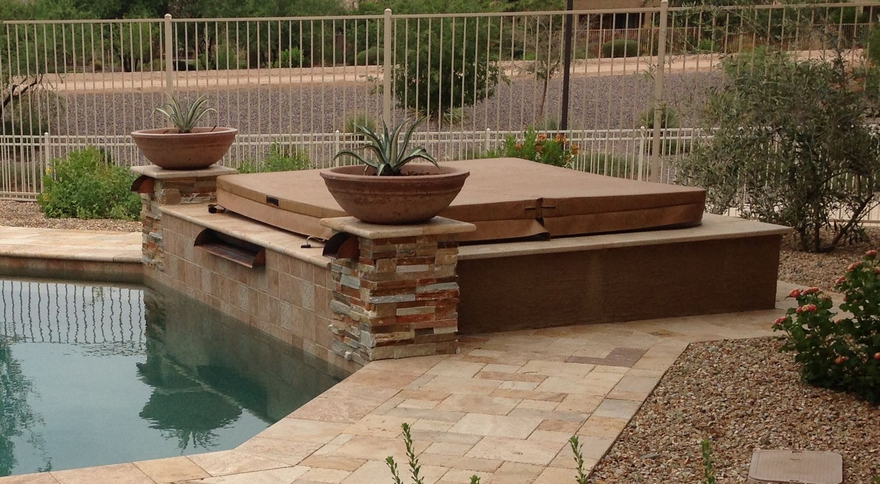 A hot tub is sitting next to a swimming pool.