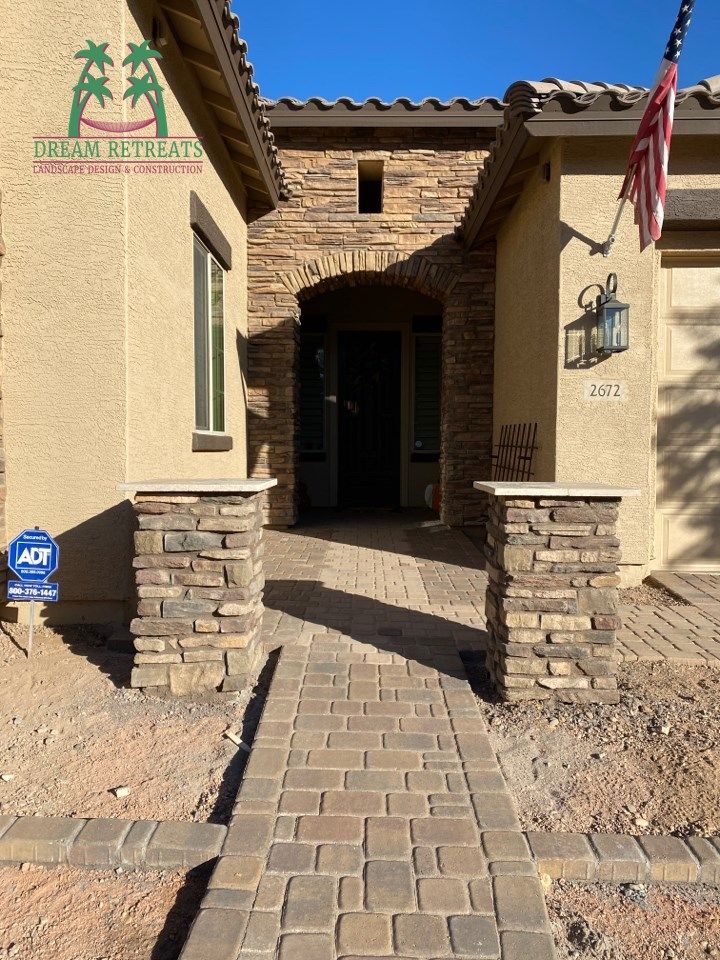 A brick walkway leading to the front door of a house