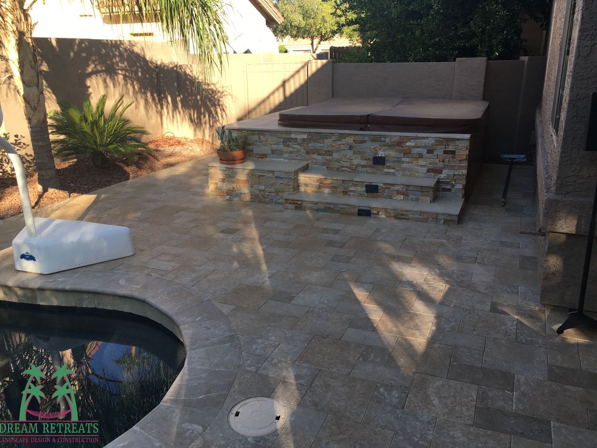 A swimming pool with a hot tub in the backyard