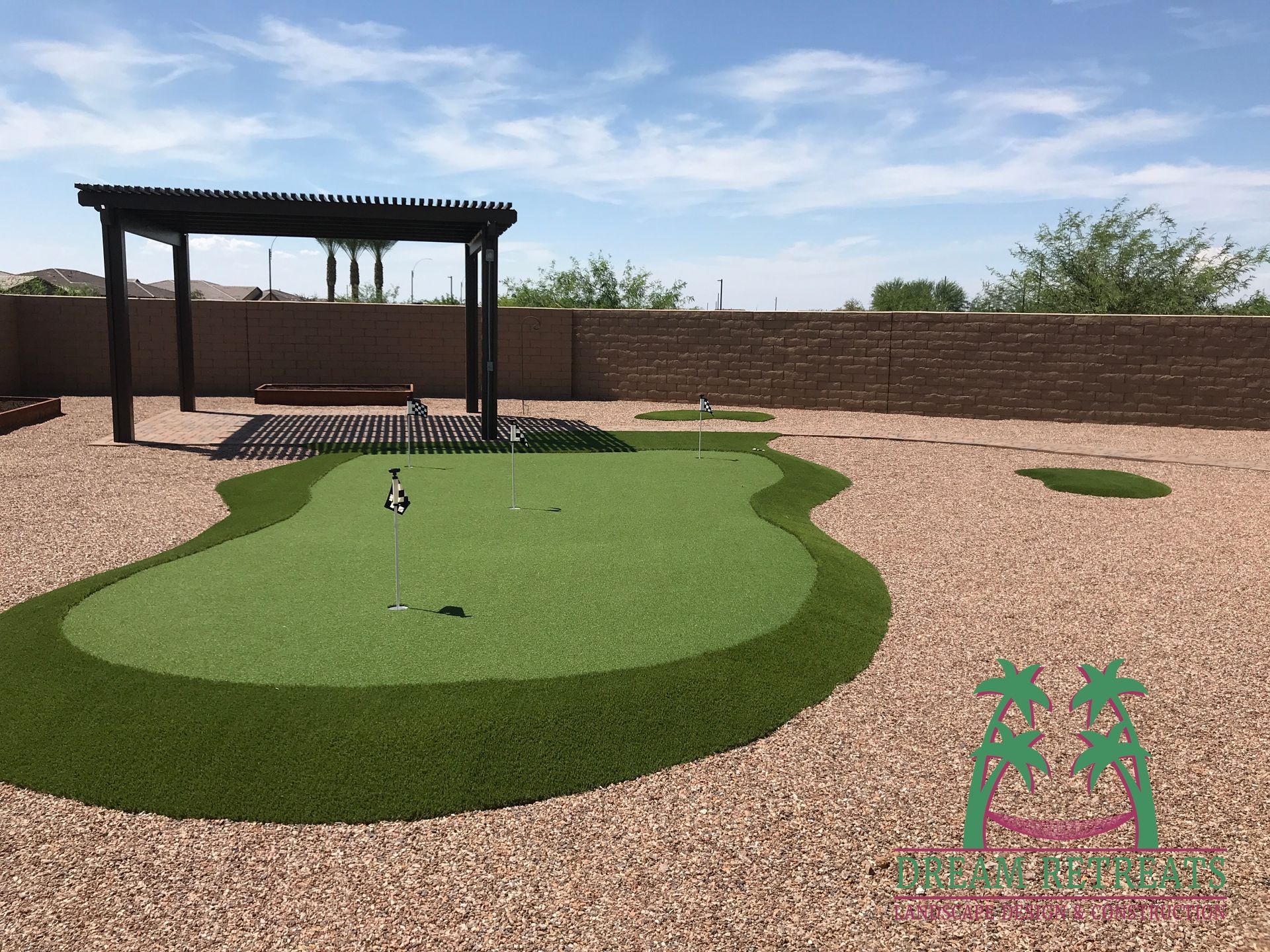 A backyard with a putting green and a pergola
