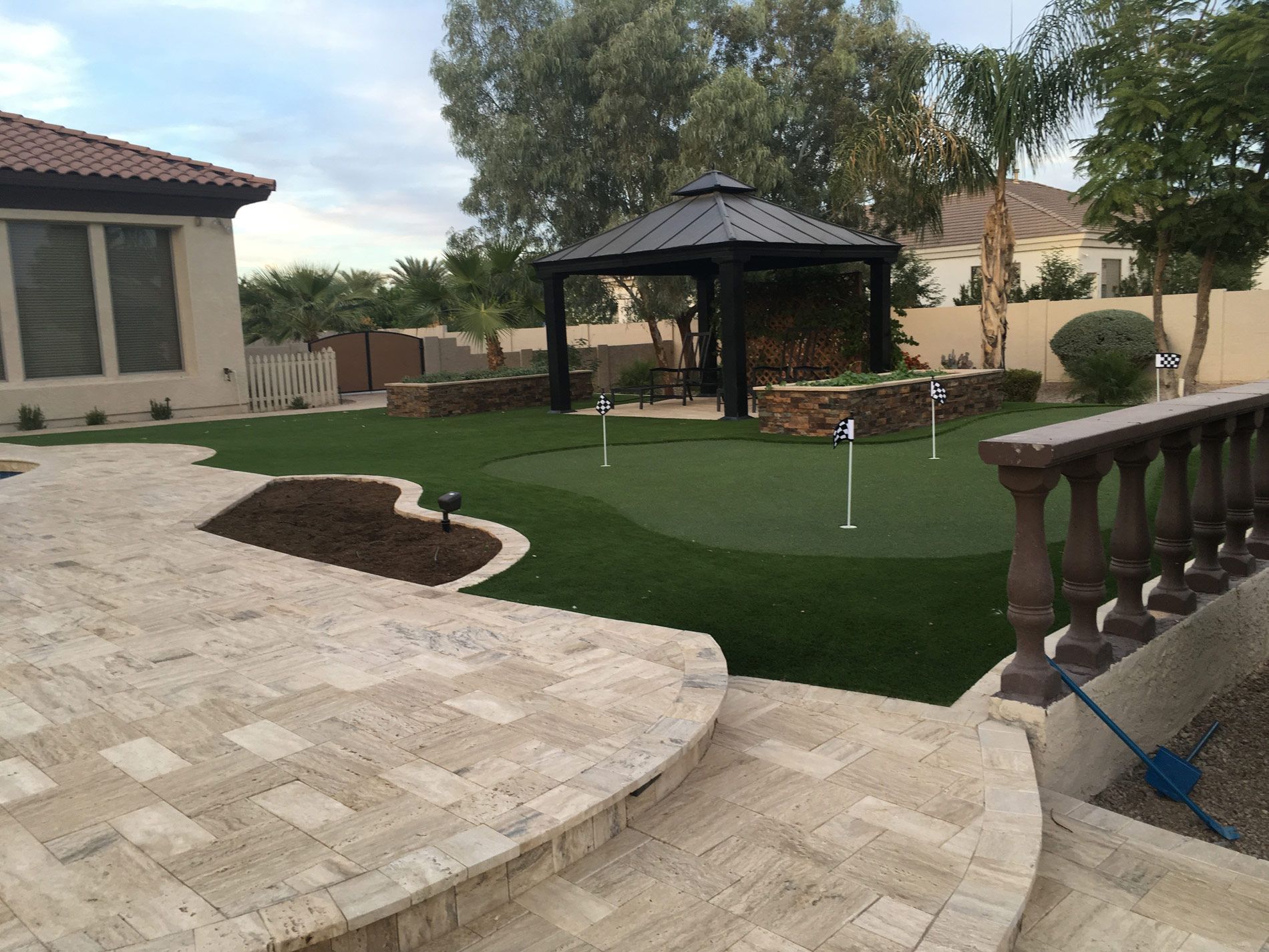 A backyard with a gazebo and a putting green
