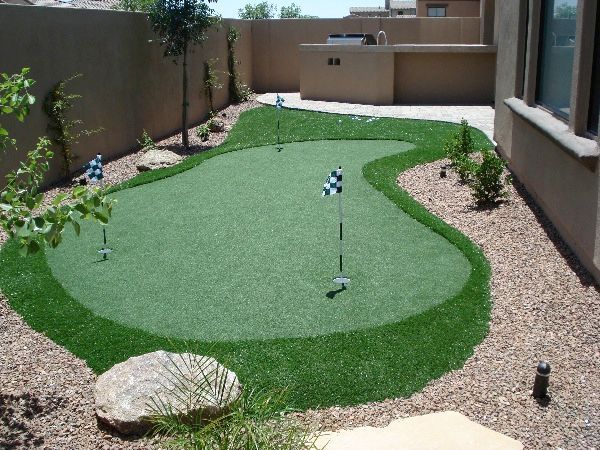 A putting green in the backyard of a house