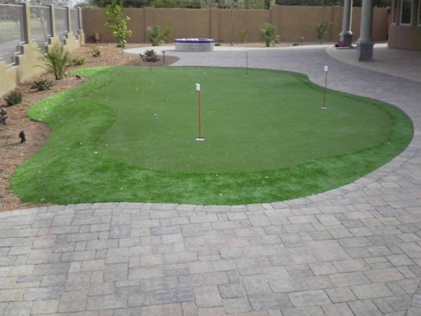 A brick patio with a putting green in the middle