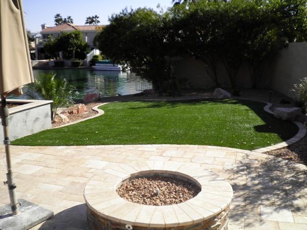 A fire pit in the middle of a lush green lawn