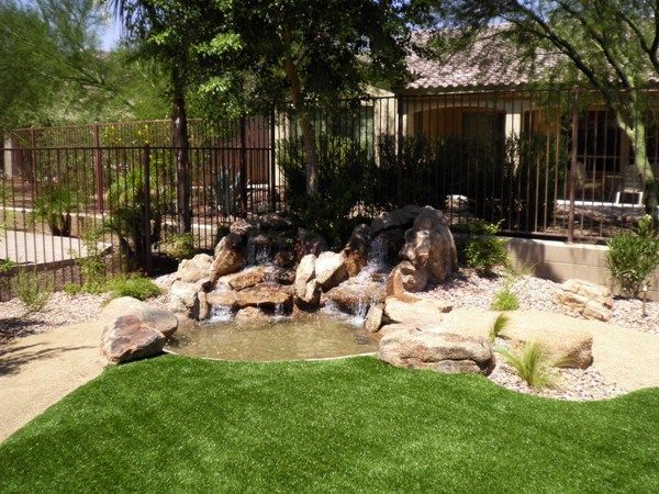 There is a waterfall in the backyard of a house.