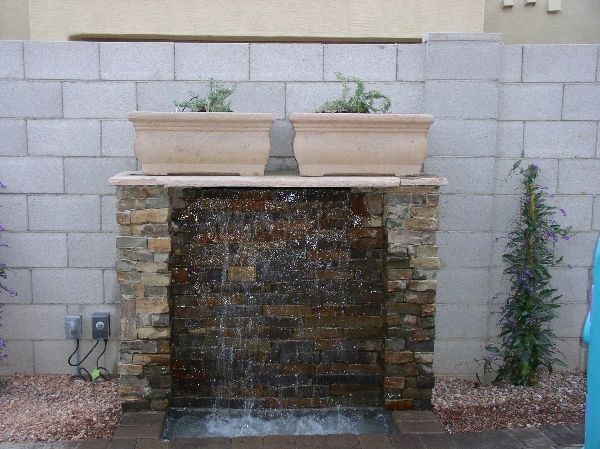 A waterfall with two potted plants on top of it