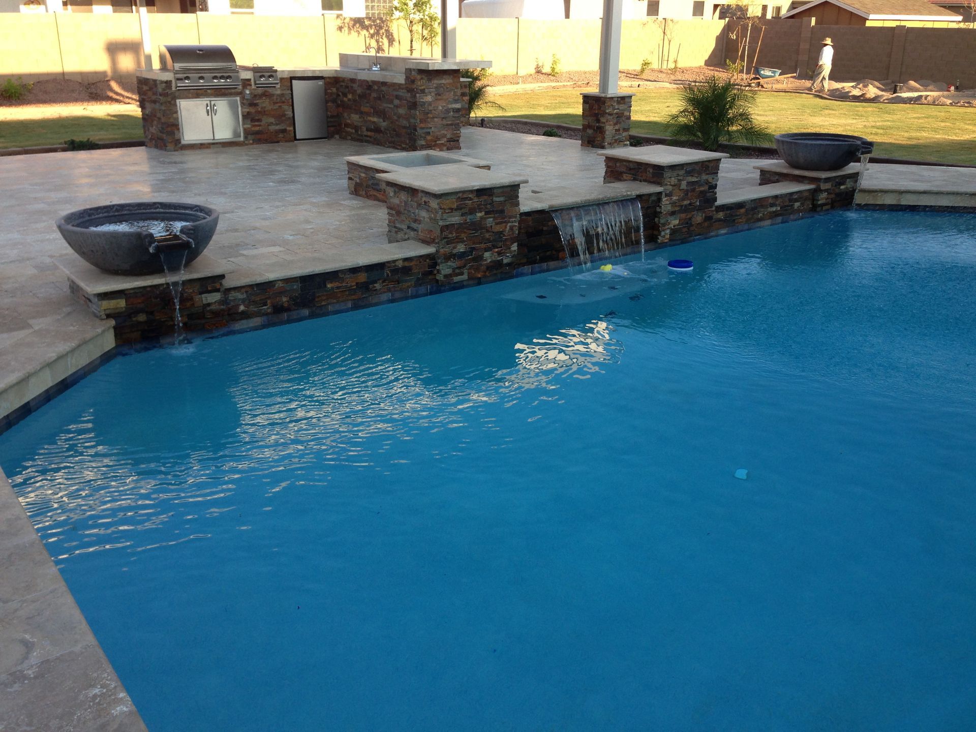 A large swimming pool with a waterfall in the middle