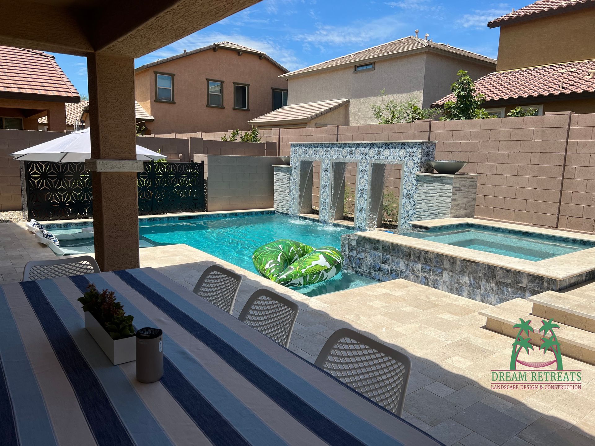 A swimming pool with a table and chairs in front of it