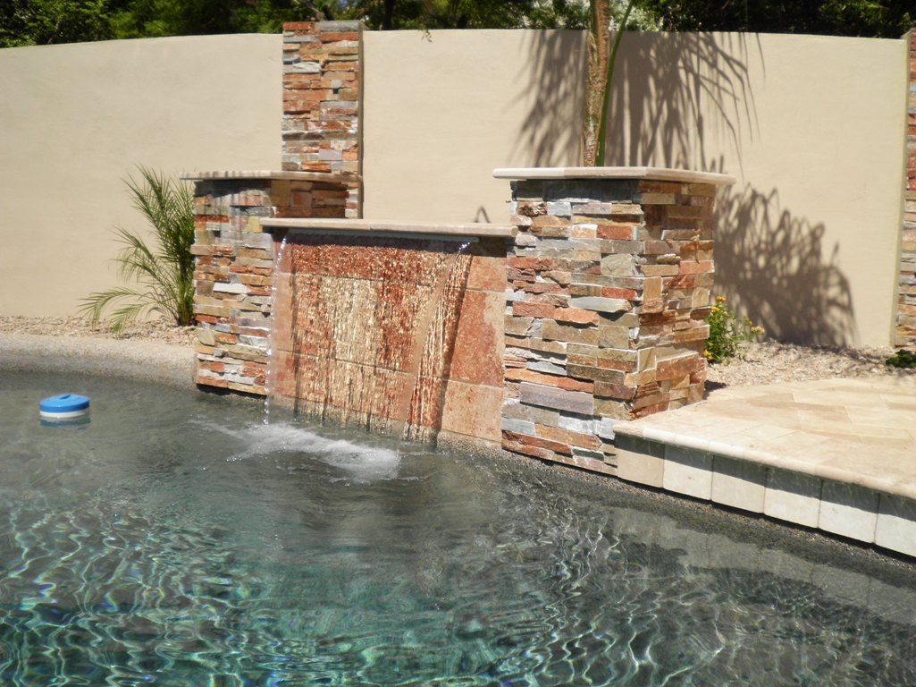 A swimming pool with a waterfall in the middle of it