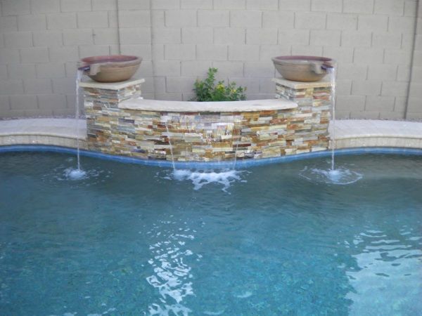 There is a waterfall in the middle of the pool.