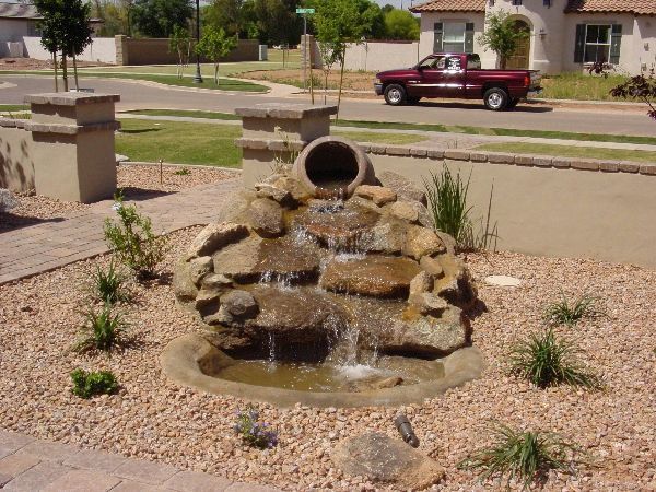 A red truck is parked in front of a water fountain