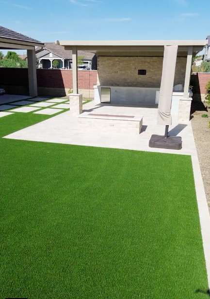 A backyard with a patio and a gazebo covered in artificial grass.