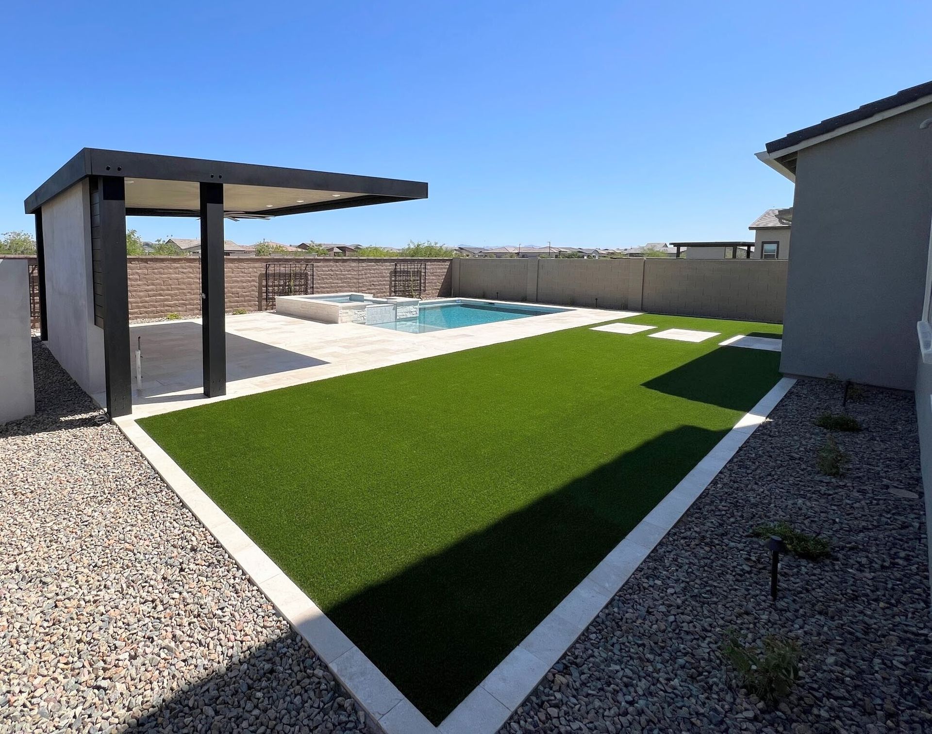 A backyard with a swimming pool and a pergola