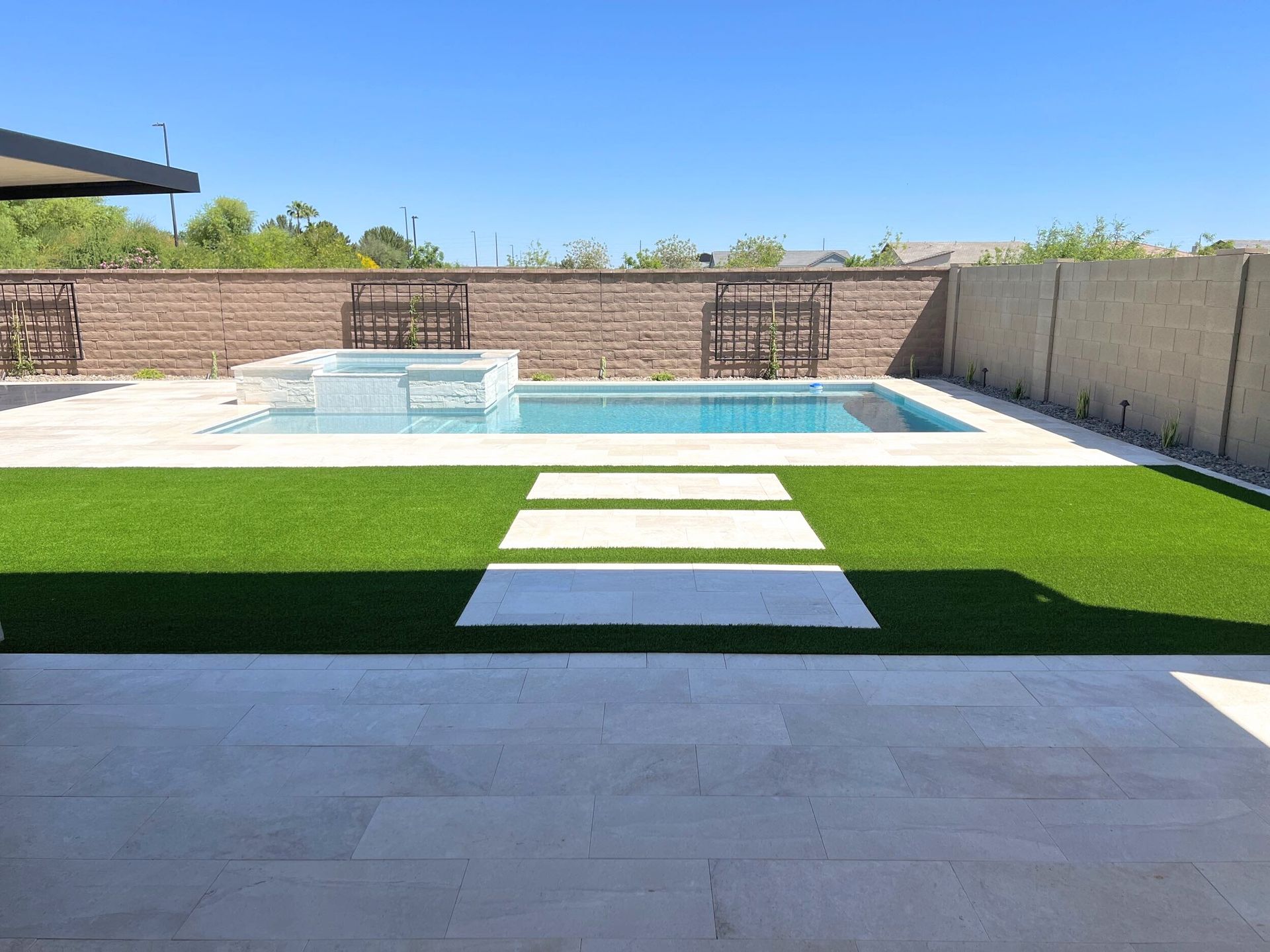 There is a swimming pool in the backyard of a house.