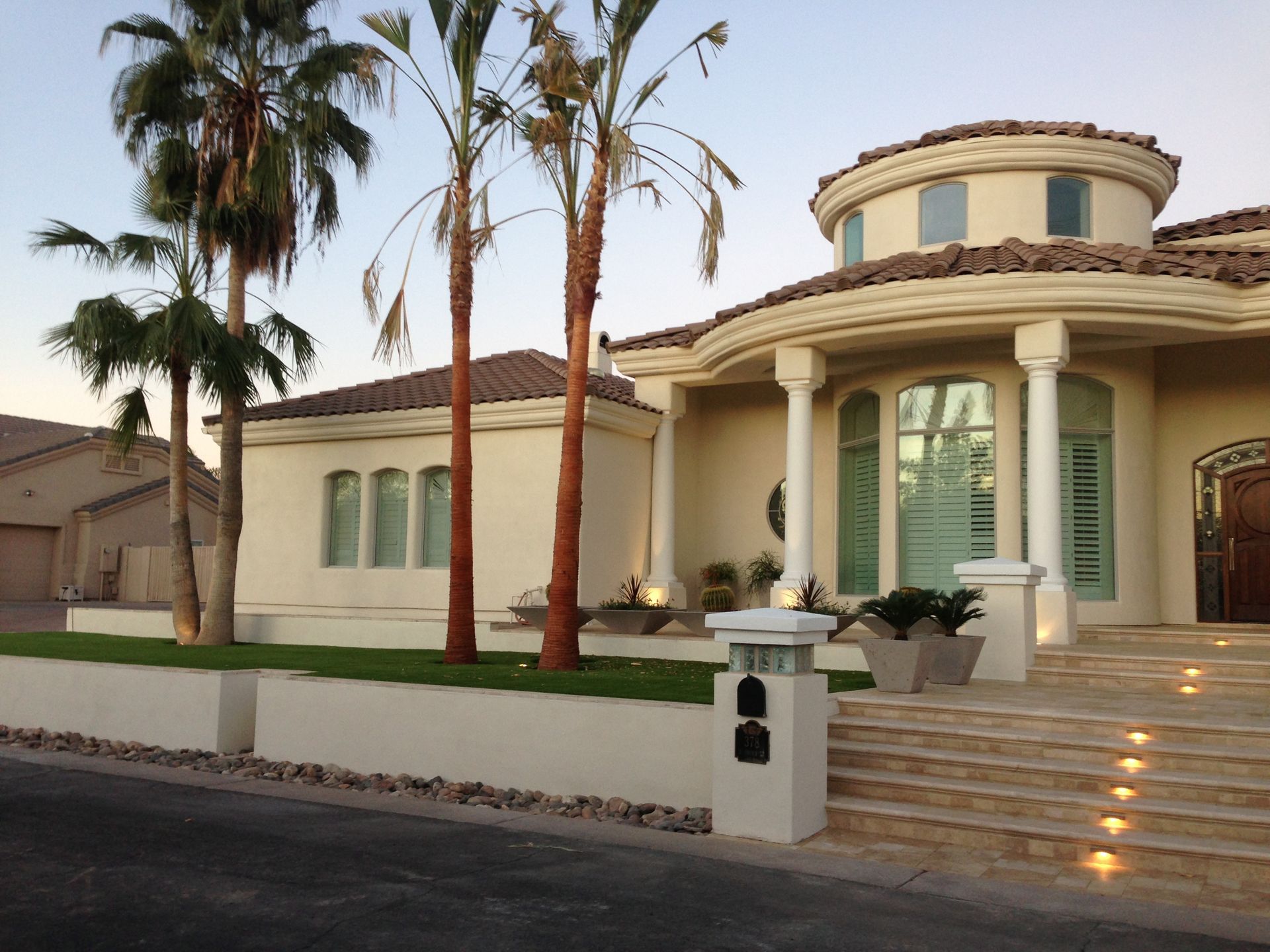 A large white house with palm trees in front of it