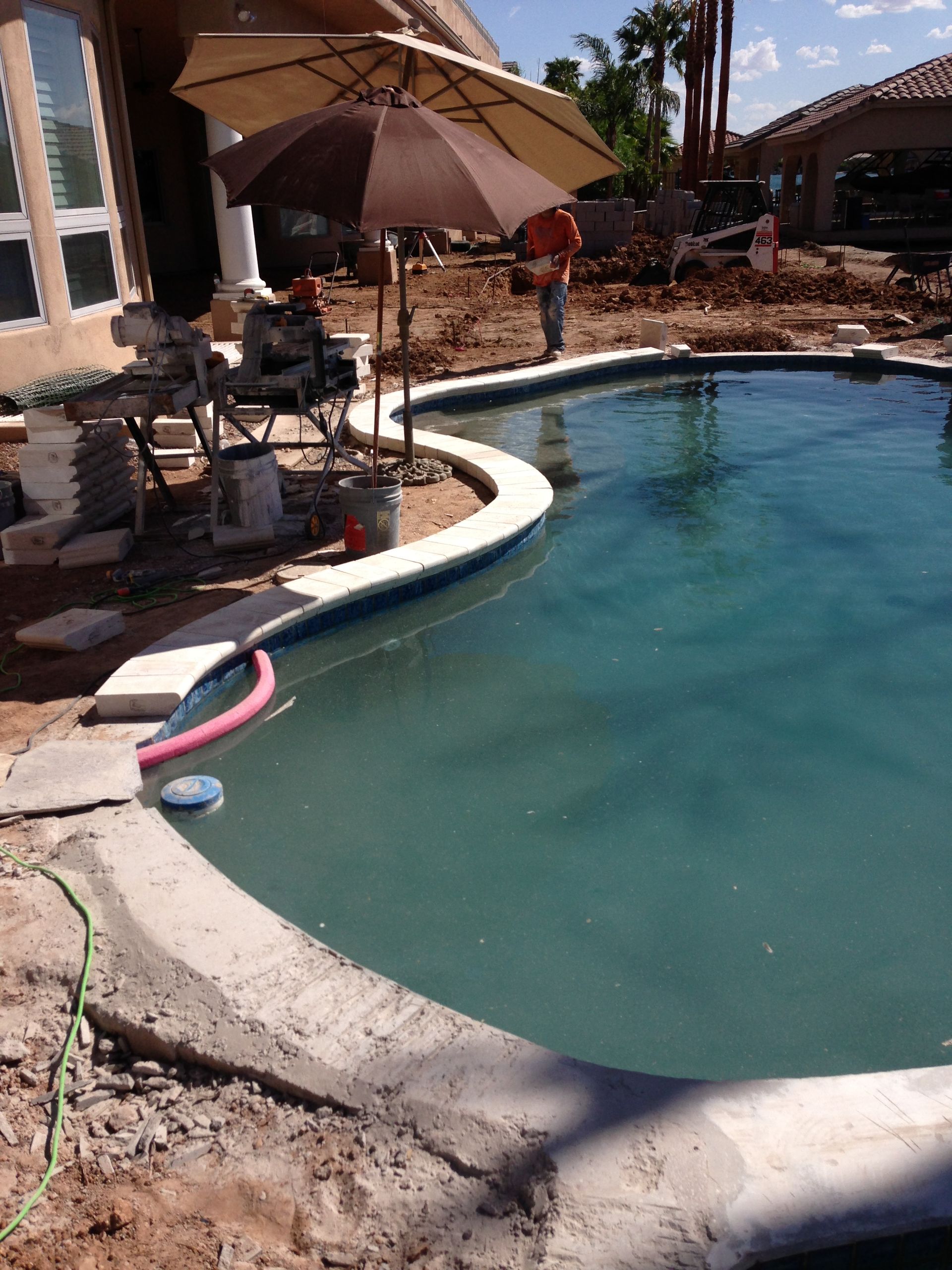 A swimming pool with a large umbrella on top of it