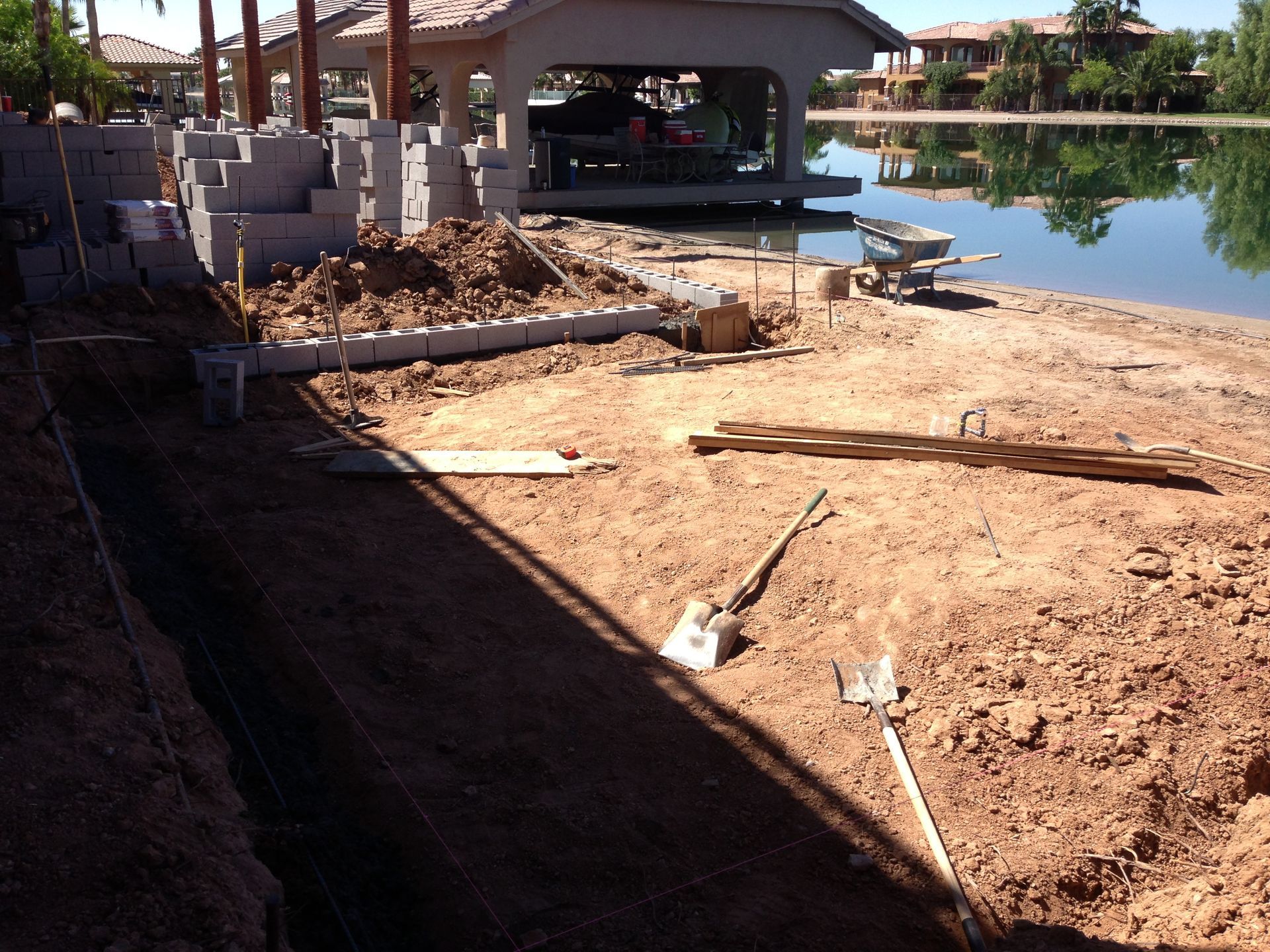 A shovel sits in the dirt in front of a building under construction