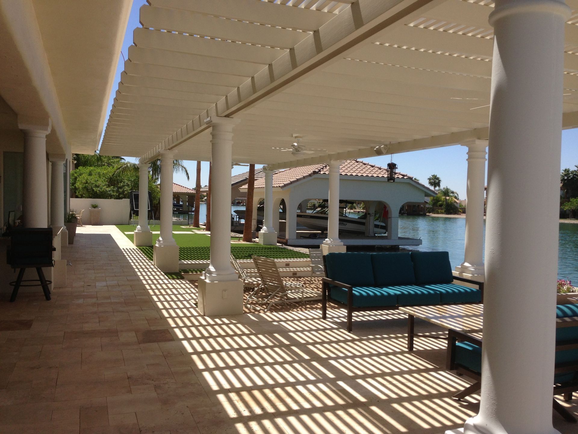 A patio with a couch and chairs under a pergola