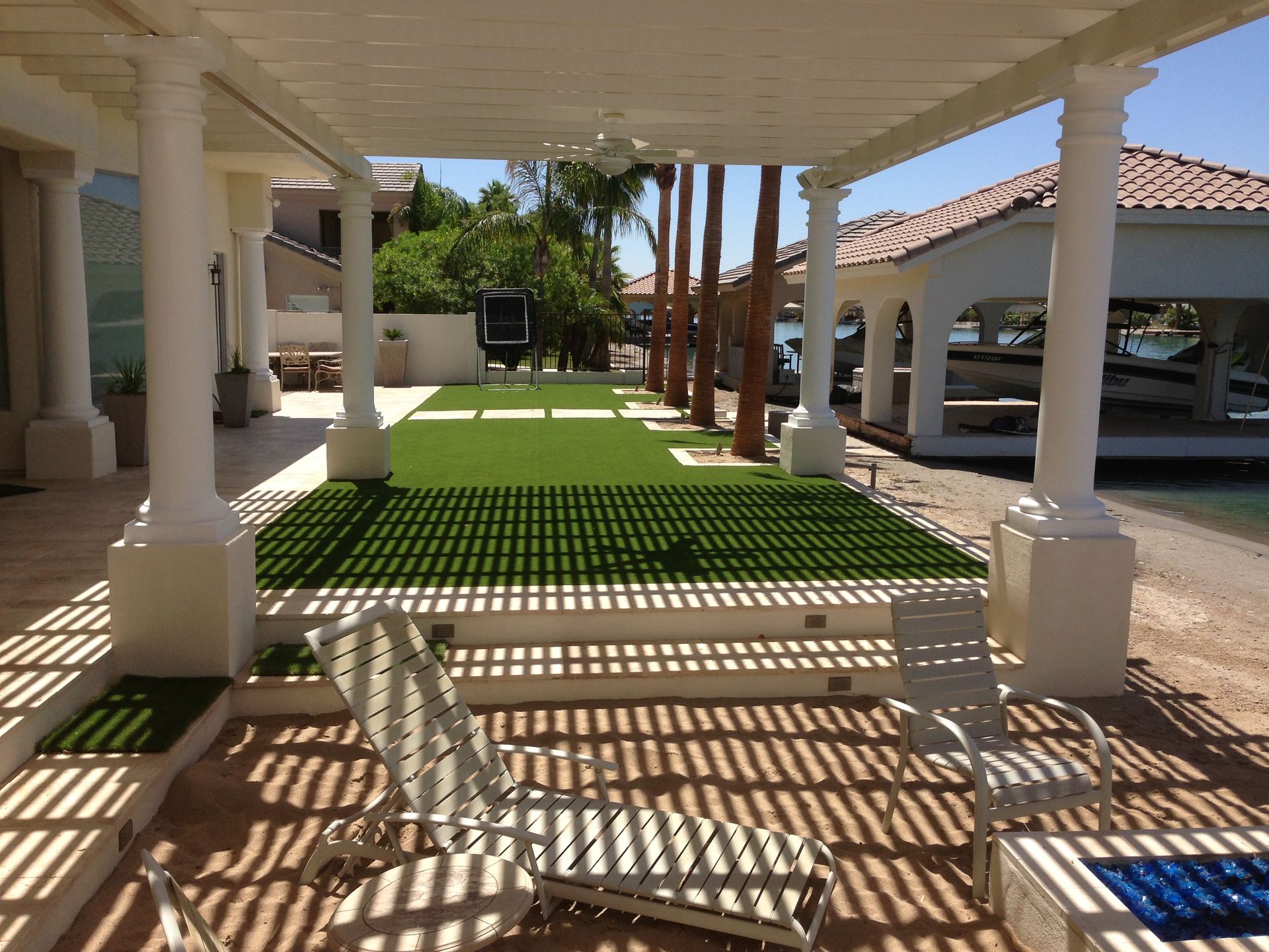 A patio area with a pergola and a lawn