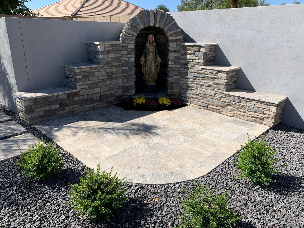 A stone wall with a statue in the middle of it