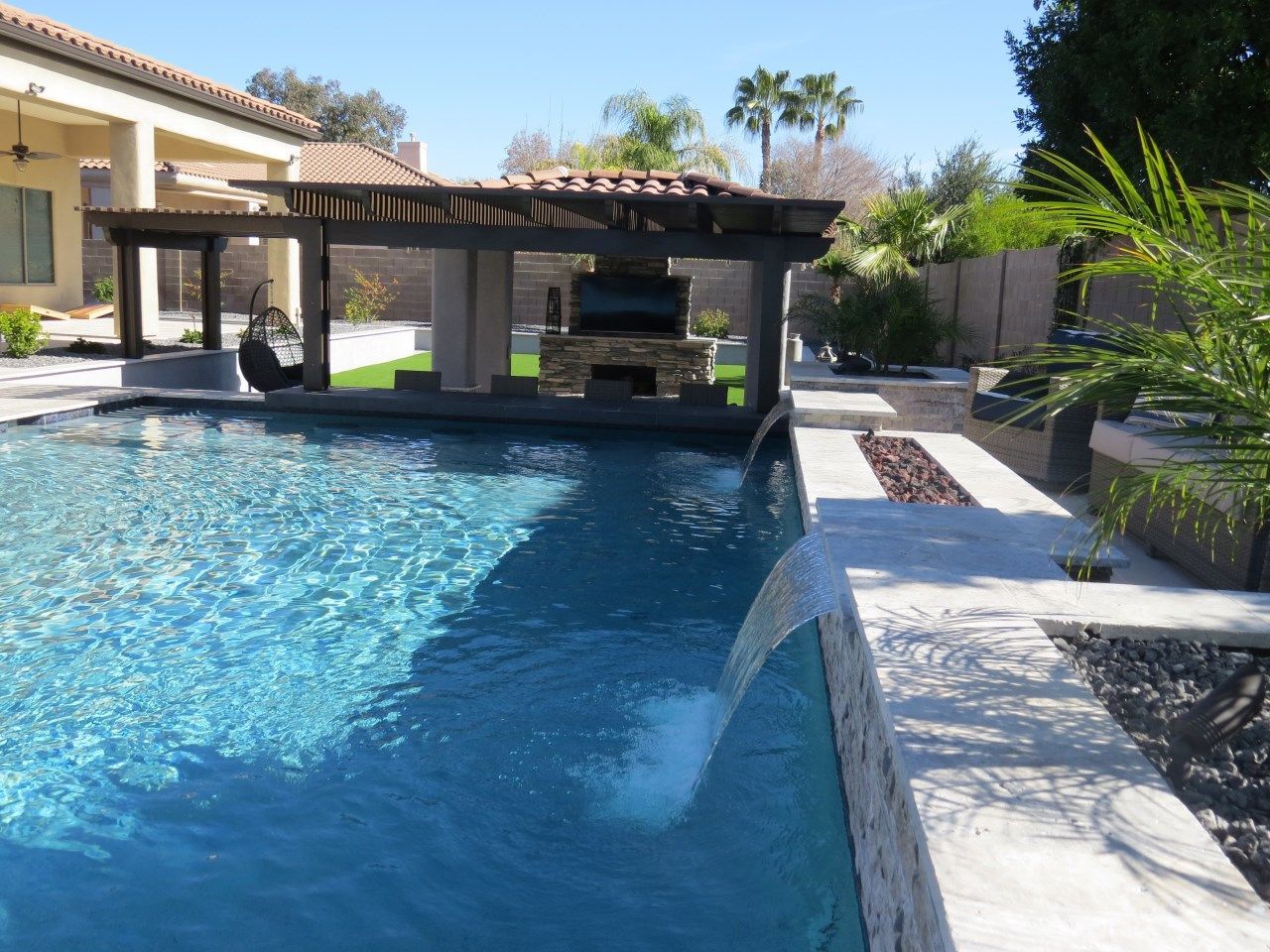 A large swimming pool with a waterfall in the middle