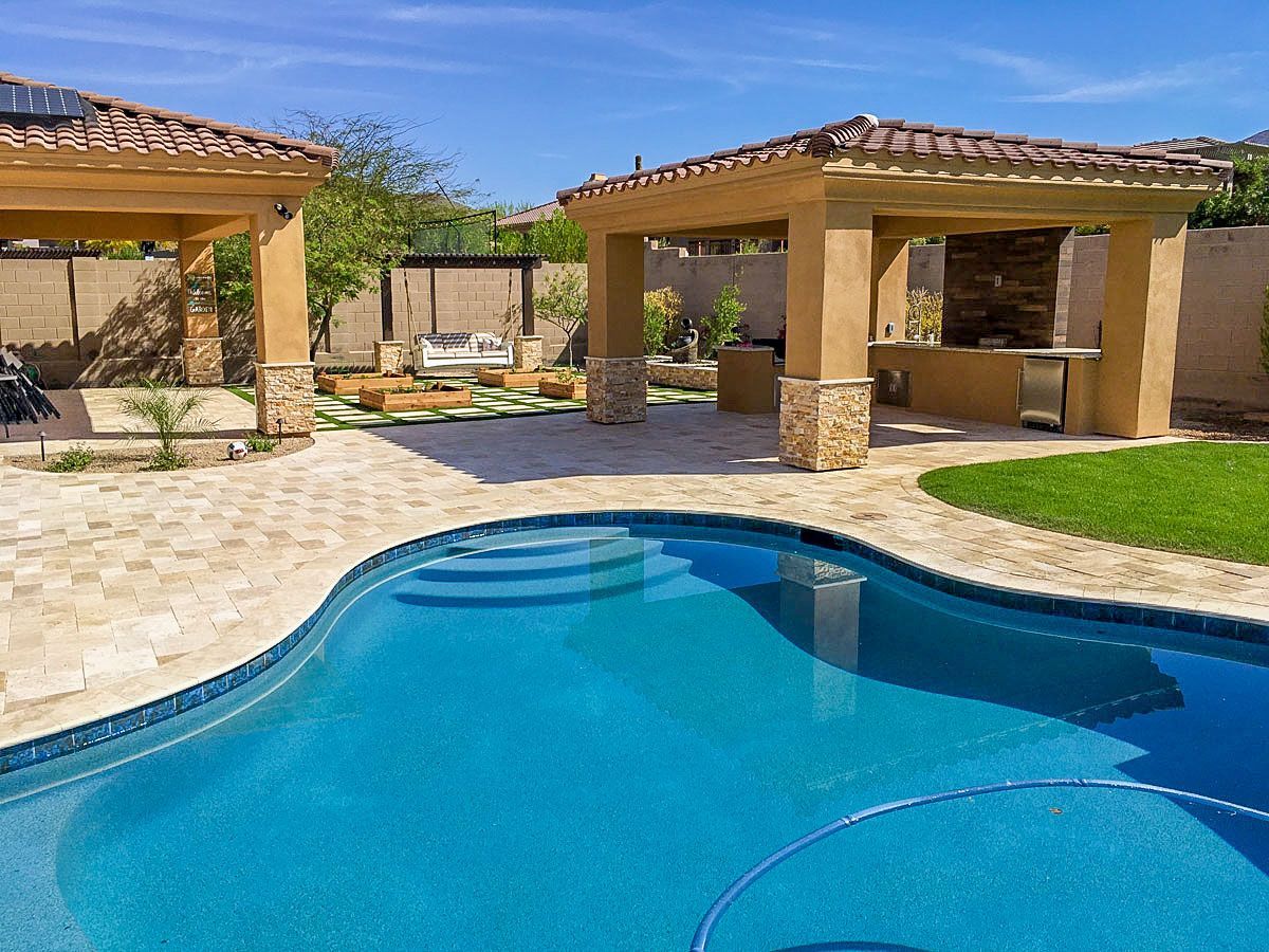 A large swimming pool with a gazebo in the background
