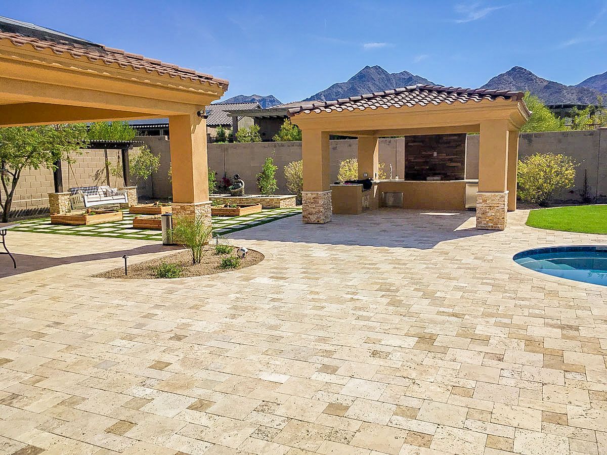 A patio with a pergola and a swimming pool in the backyard of a house.