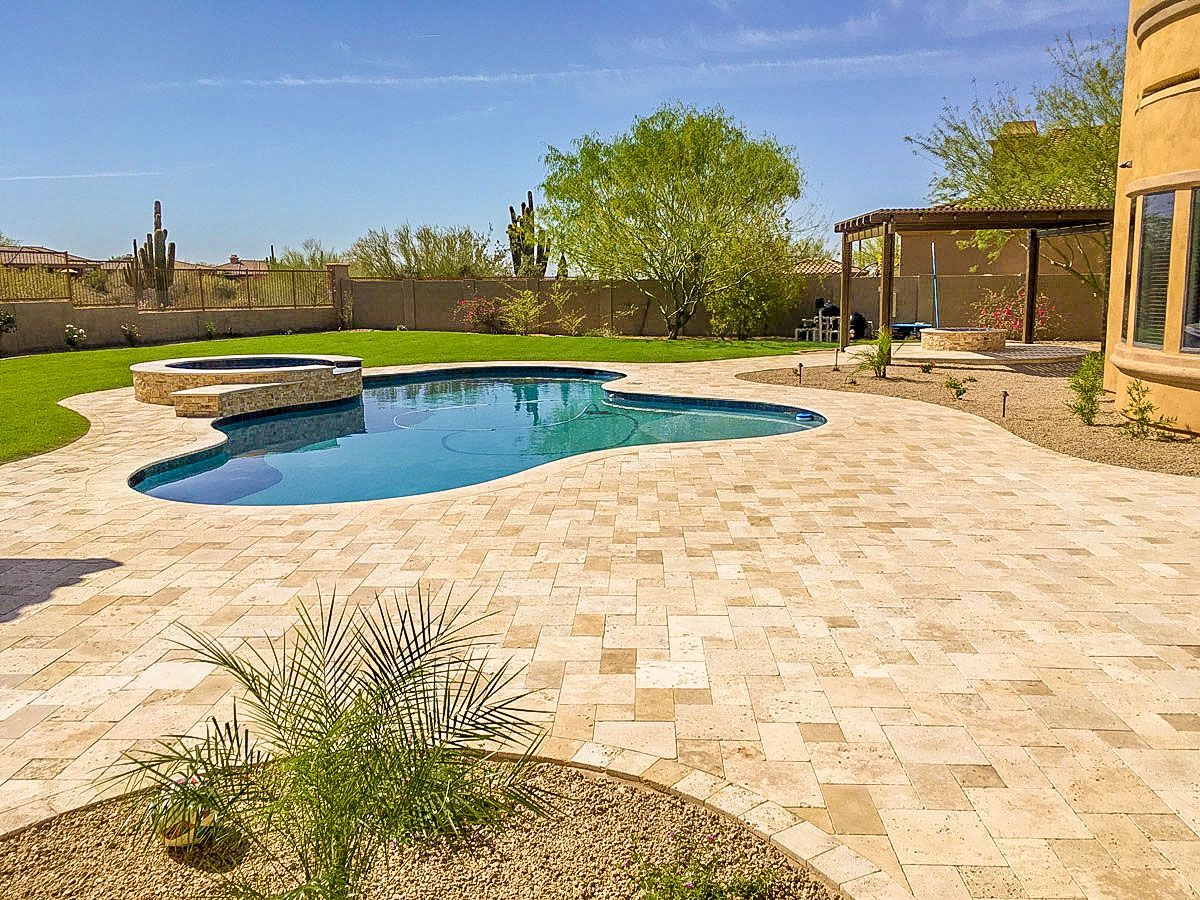 There is a large swimming pool in the backyard of a house.