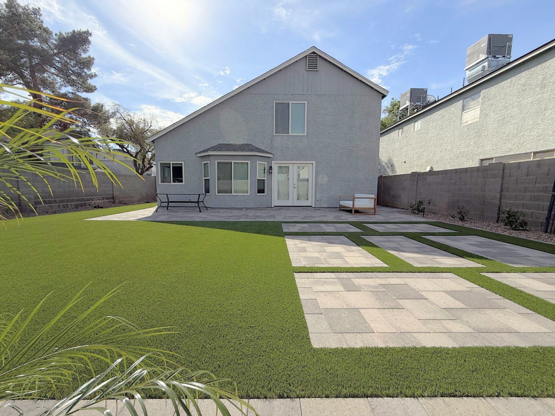 The backyard of a house with a large lawn and a patio
