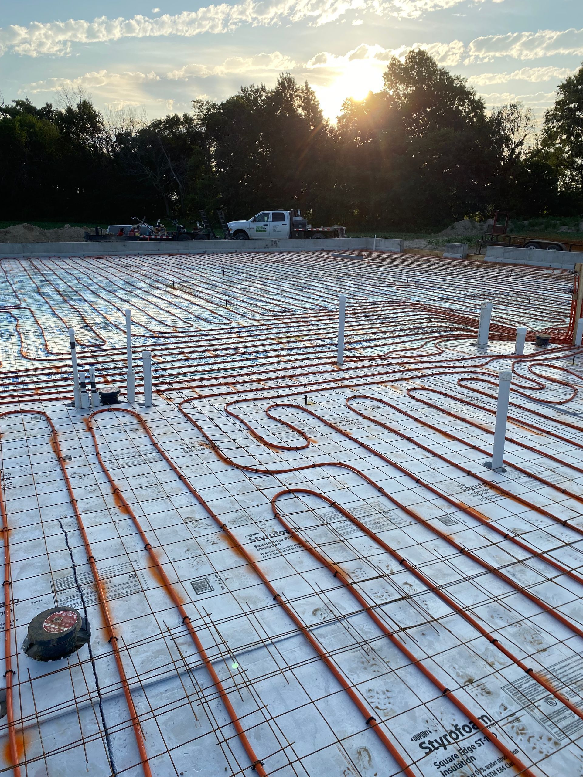 A construction site with a lot of pipes on the ground